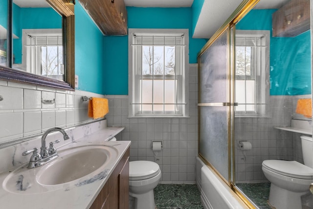 9069 Pierson St, Detroit, MI 48228 - full bathroom featuring tile walls, toilet, healthy amount of natural light, wainscoting, and vanity
