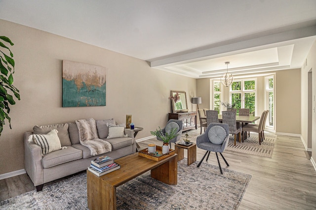 4804 Eagle Springs Ct, Clarkston, MI 48348 - living area with baseboards, light wood-style flooring, a chandelier, and a tray ceiling
