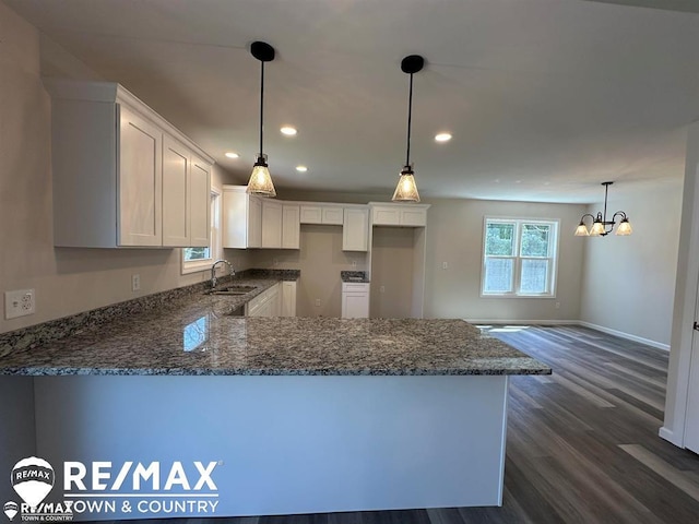 1208 Turrill Rd, Lapeer, MI 48446 - kitchen featuring a sink, a peninsula, dark stone counters, dark wood-type flooring, and recessed lighting
