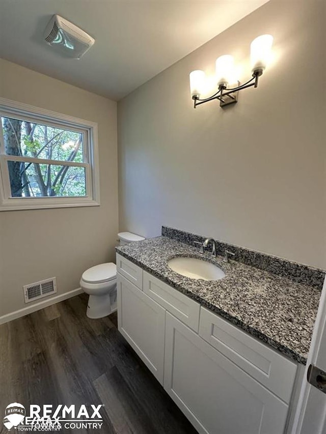 1208 Turrill Rd, Lapeer, MI 48446 - half bathroom featuring vanity, wood finished floors, toilet, and baseboards