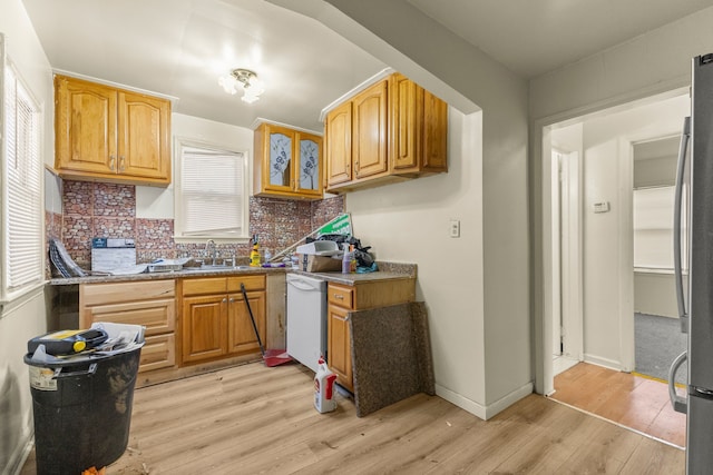 7285 Mansfield St, Detroit, MI 48228 - kitchen featuring a sink, light wood-style floors, tasteful backsplash, white dishwasher, and freestanding refrigerator