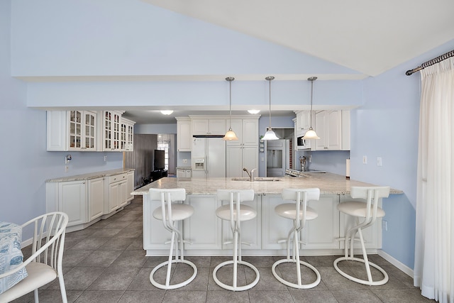 804 E Avon Rd, Rochester Hills, MI 48307 - kitchen featuring white appliances, a peninsula, vaulted ceiling, glass insert cabinets, and a breakfast bar