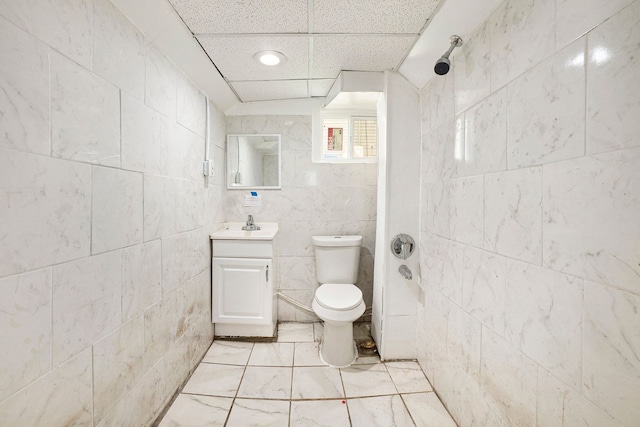 7260 Cadillac Ave, Warren, MI 48091 - bathroom featuring a shower, toilet, vanity, a paneled ceiling, and tile walls