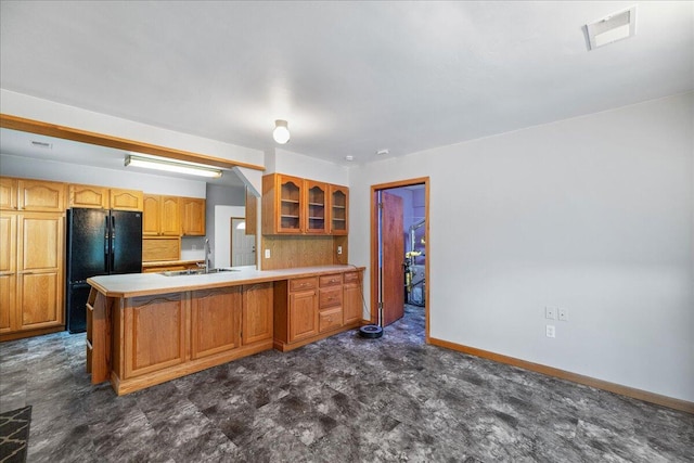 45 E Beech St, Fruitport, MI 49415 - kitchen featuring freestanding refrigerator, glass insert cabinets, a peninsula, light countertops, and a sink