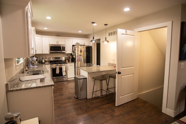 1226 E Bernhard Ave, Hazel Park, MI 48030 - kitchen with appliances with stainless steel finishes, a sink, dark wood-type flooring, light stone counters, and white cabinetry