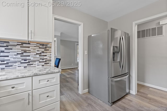 24371 Grove Ave, Eastpointe, MI 48021 - kitchen featuring stainless steel refrigerator with ice dispenser, a baseboard radiator, light wood-type flooring, and white cabinetry