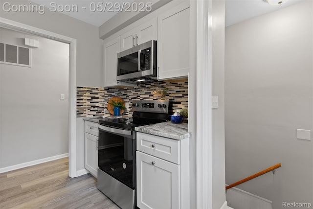 24371 Grove Ave, Eastpointe, MI 48021 - kitchen featuring appliances with stainless steel finishes, tasteful backsplash, white cabinets, light wood-style floors, and light countertops