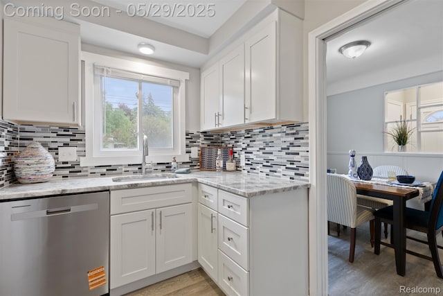 24371 Grove Ave, Eastpointe, MI 48021 - kitchen with stainless steel dishwasher, a sink, light wood-style floors, white cabinetry, and light stone countertops