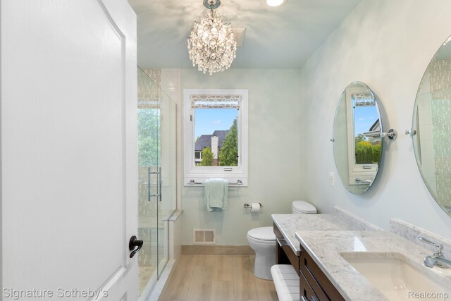 615 Appoline Ct, Rochester, MI 48307 - full bathroom with a chandelier, vanity, a stall shower, toilet, and wood finished floors