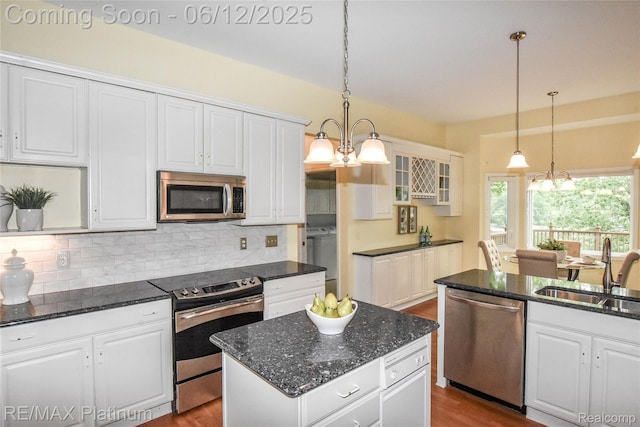8342 Islandview Ct, Brighton, MI 48114 - kitchen with appliances with stainless steel finishes, a sink, white cabinetry, decorative backsplash, and dark stone countertops