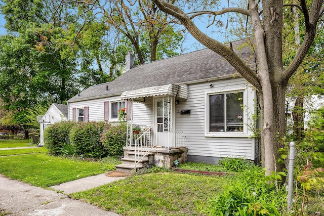 21 Woolworth, Mount Clemens, MI 48043 - view of front of house featuring a front yard, roof with shingles, and a chimney