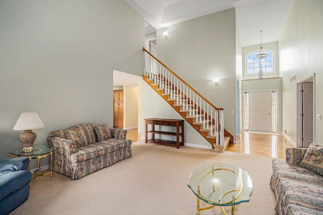 4024 Hosner Rd, Metamora, MI 48455 - living area featuring a towering ceiling, stairs, carpet flooring, and baseboards