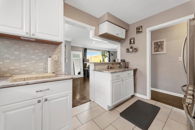 23830 Shakespeare Ave, Eastpointe, MI 48021 - kitchen with freestanding refrigerator, decorative backsplash, white cabinetry, and light tile patterned floors