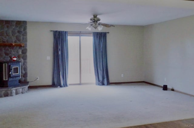9421 Springville Hwy, Onsted, MI 49265 - carpeted empty room featuring a wood stove, a ceiling fan, and baseboards