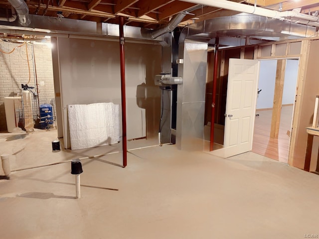 9421 Springville Hwy, Onsted, MI 49265 - unfinished below grade area with a water softener system and brick wall