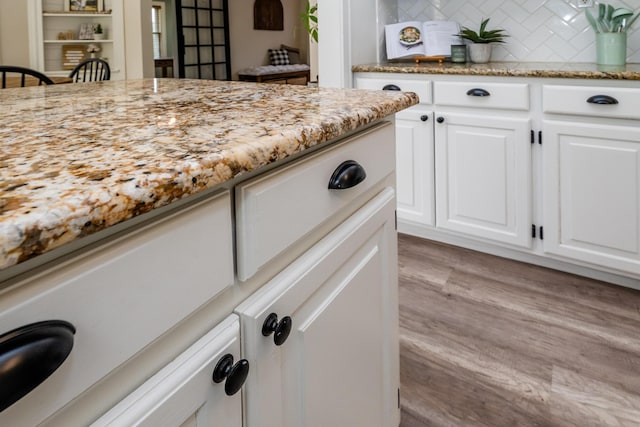 5915 S Pipestone Rd, Eau Claire, MI 49111 - kitchen with backsplash, light wood-style flooring, light stone counters, and white cabinets