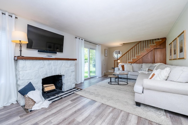 5915 S Pipestone Rd, Eau Claire, MI 49111 - living room with wood finished floors, stairs, a stone fireplace, and ornamental molding