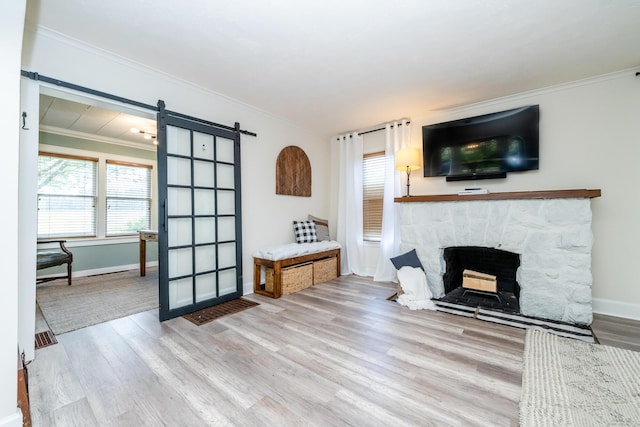 5915 S Pipestone Rd, Eau Claire, MI 49111 - living area featuring a barn door, wood finished floors, crown molding, and healthy amount of natural light