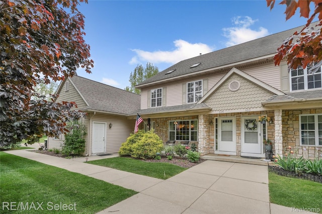 604 Fenton Commons Ln, Fenton, MI 48430 - multi unit property featuring stone siding, a front yard, and roof with shingles