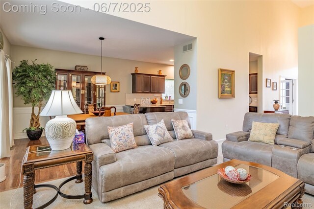 791 Glen Meadows Dr, South Lyon, MI 48178 - living area featuring a towering ceiling and wood finished floors