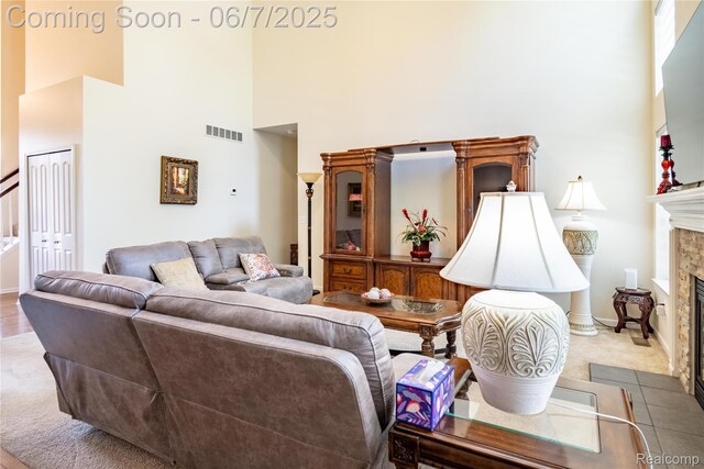 791 Glen Meadows Dr, South Lyon, MI 48178 - carpeted living room with a high ceiling, a fireplace, and baseboards