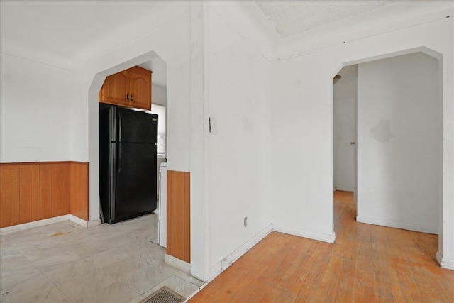 21803 Brittany Ave, Eastpointe, MI 48021 - empty room with arched walkways, wainscoting, baseboards, and wood walls