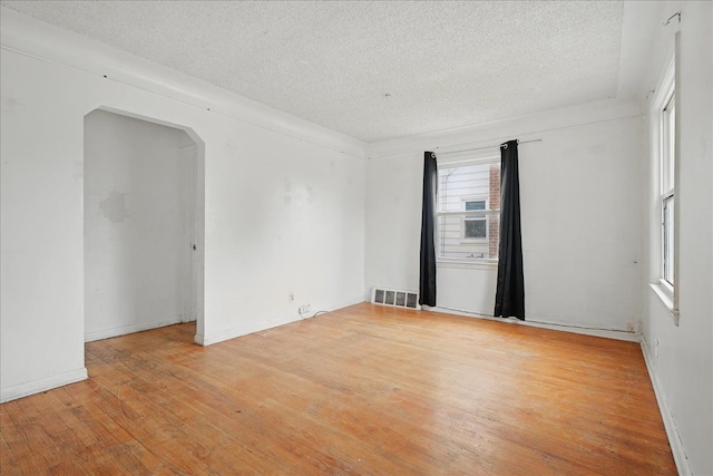 21803 Brittany Ave, Eastpointe, MI 48021 - empty room featuring a textured ceiling, wood finished floors, arched walkways, and baseboards