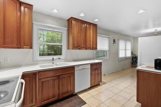 kitchen with white dishwasher, a sink, light tile patterned flooring, light countertops, and brown cabinets