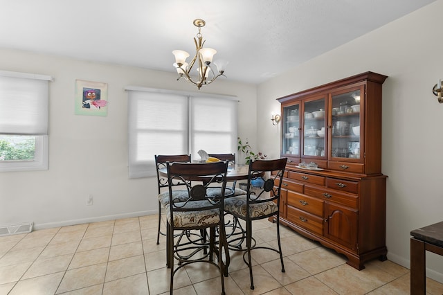 dining room with a chandelier, baseboards, and light tile patterned flooring
