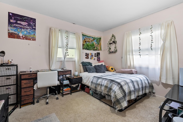 bedroom with light colored carpet and an office area