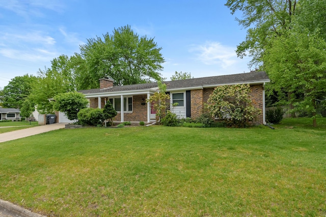 single story home with brick siding, a front lawn, a chimney, and concrete driveway