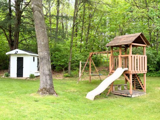view of play area with a lawn and a wooded view