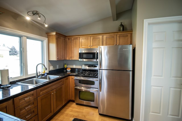 13496 S Horrell Rd, Fenton, MI 48430 - kitchen with stainless steel appliances, vaulted ceiling, a sink, light wood-style flooring, and brown cabinetry
