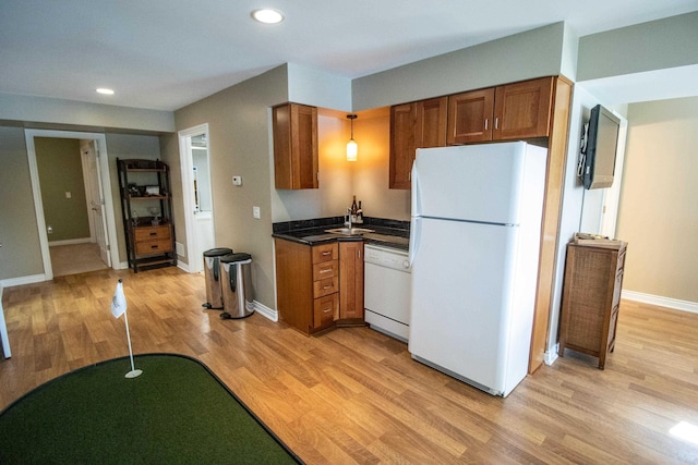 13496 S Horrell Rd, Fenton, MI 48430 - kitchen with white appliances, brown cabinetry, light wood-style floors, dark countertops, and baseboards