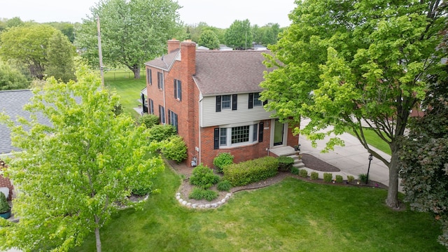 2366 Grange Rd, Trenton, MI 48183 - view of front of house featuring brick siding, a front yard, a chimney, and a shingled roof