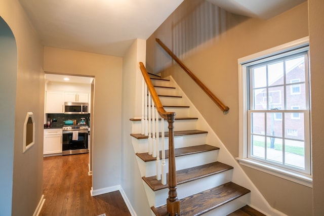2366 Grange Rd, Trenton, MI 48183 - staircase featuring wood finished floors, arched walkways, and baseboards