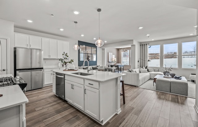 4082 Nottingham Cir, Clarkston, MI 48346 - kitchen with stainless steel appliances, a sink, open floor plan, light countertops, and wood finished floors