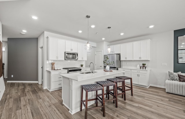 4082 Nottingham Cir, Clarkston, MI 48346 - kitchen featuring appliances with stainless steel finishes, a sink, decorative backsplash, a kitchen bar, and recessed lighting