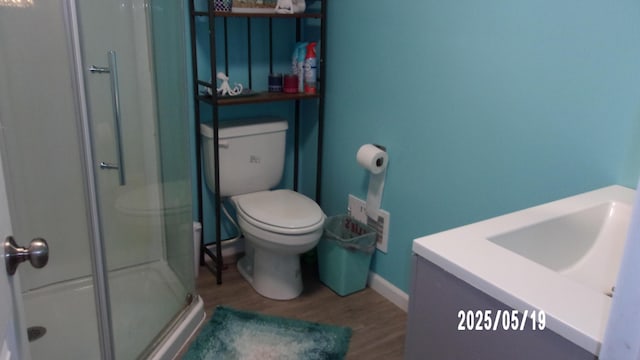 823 21st St, Jackson, MI 49203 - bathroom featuring wood finished floors, a shower stall, toilet, and vanity