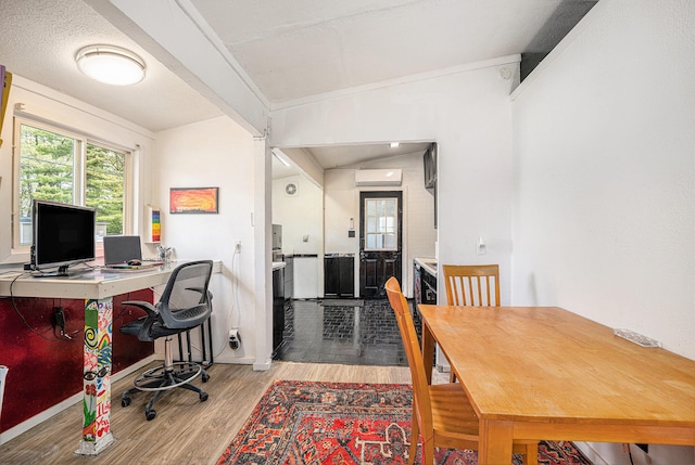 office space featuring a wall unit AC, wood finished floors, and lofted ceiling