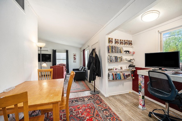 office space featuring lofted ceiling, wood finished floors, and healthy amount of natural light