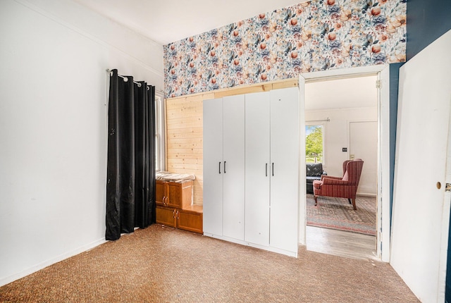 bedroom with light carpet and wallpapered walls