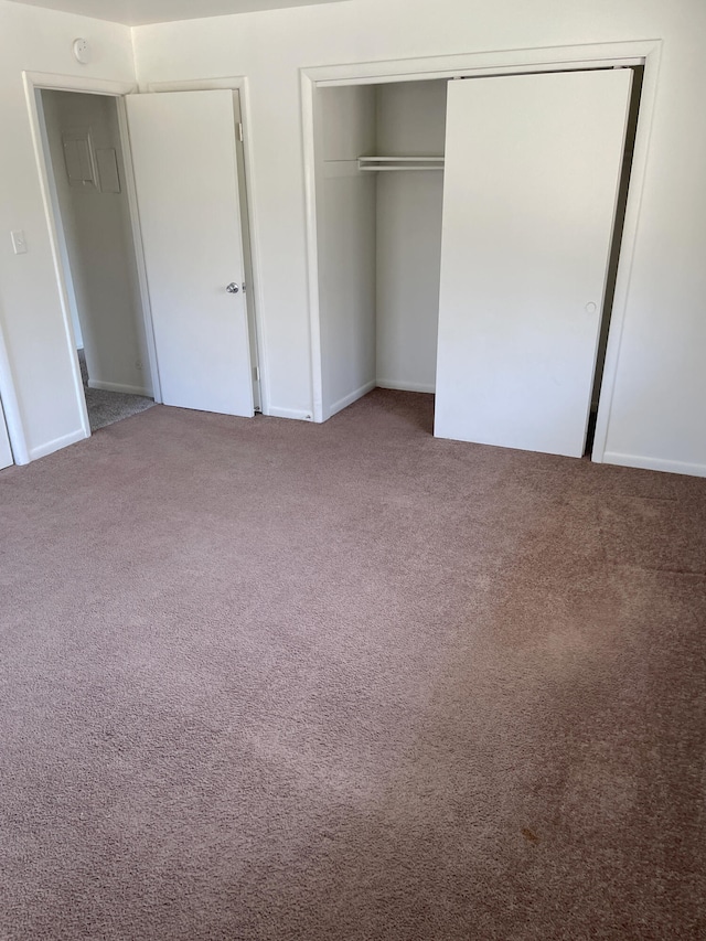 unfurnished bedroom featuring carpet floors and a closet