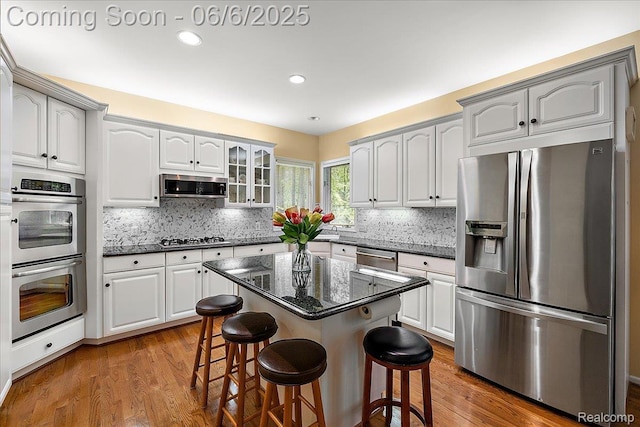 53629 Wayburn Ct, Utica, MI 48315 - kitchen featuring stainless steel appliances, a kitchen bar, wood finished floors, tasteful backsplash, and recessed lighting