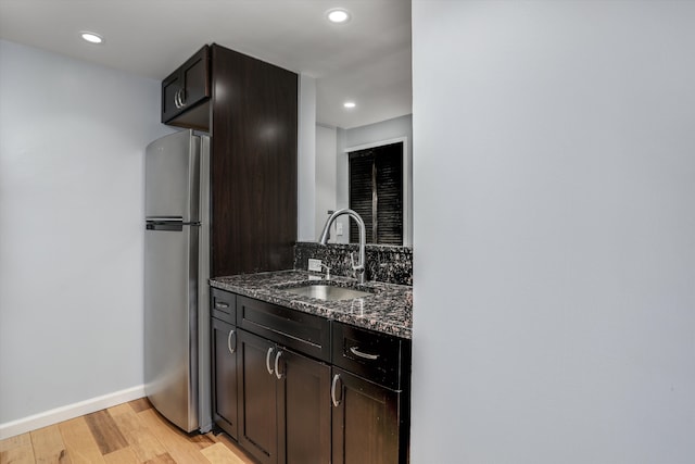 1300 E Lafayette St Unit 1604, Detroit, MI 48207 - kitchen with freestanding refrigerator, a sink, light wood finished floors, dark stone countertops, and recessed lighting