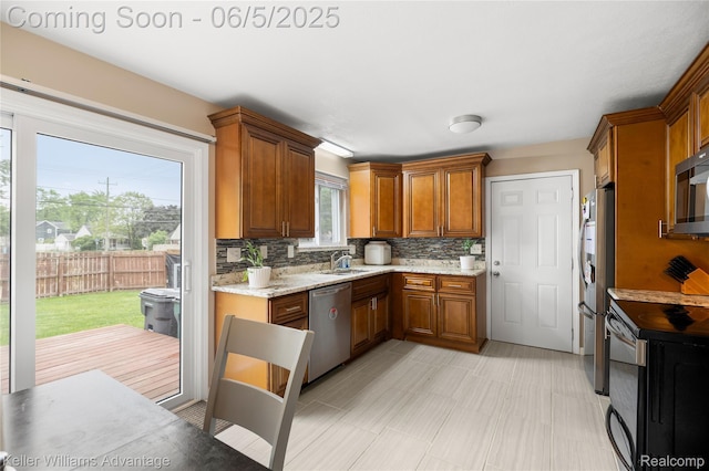 3714 Prairie Ave, Berkley, MI 48072 - kitchen featuring appliances with stainless steel finishes, brown cabinets, decorative backsplash, and a sink