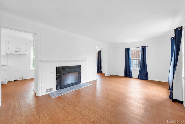 20036 Appoline St, Detroit, MI 48235 - unfurnished living room featuring a fireplace with flush hearth, healthy amount of natural light, light wood-type flooring, and baseboards