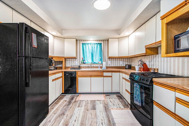 61564 Park St, Cassopolis, MI 49031 - kitchen with black appliances, a sink, light wood finished floors, white cabinetry, and light countertops