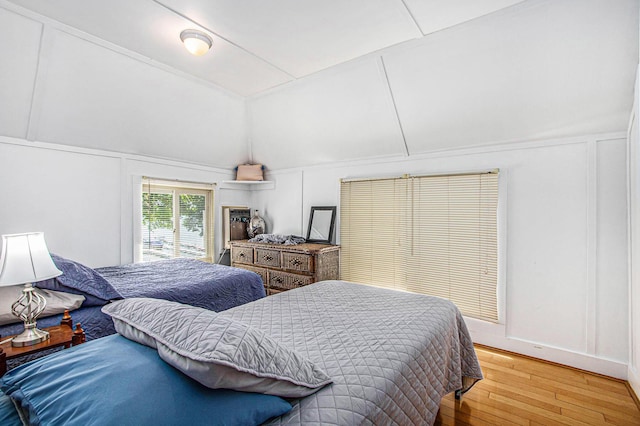 61564 Park St, Cassopolis, MI 49031 - bedroom featuring vaulted ceiling, a decorative wall, and hardwood / wood-style floors