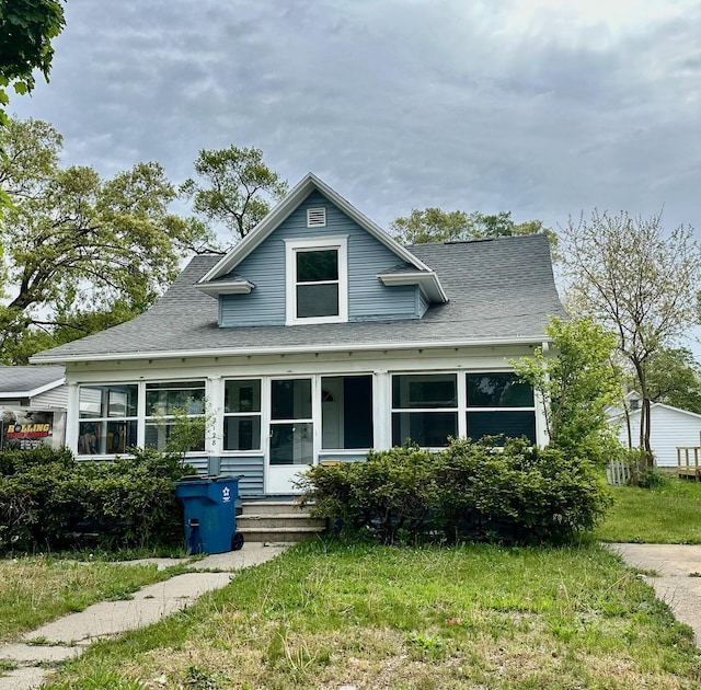 bungalow featuring a shingled roof and a front yard